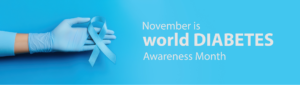 A gloved hand holds a blue ribbon for World Diabetes Month in November, promoting diabetes awareness and support.