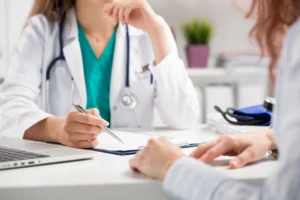 A doctor discussing health details with a patient during a primary care physical examination.