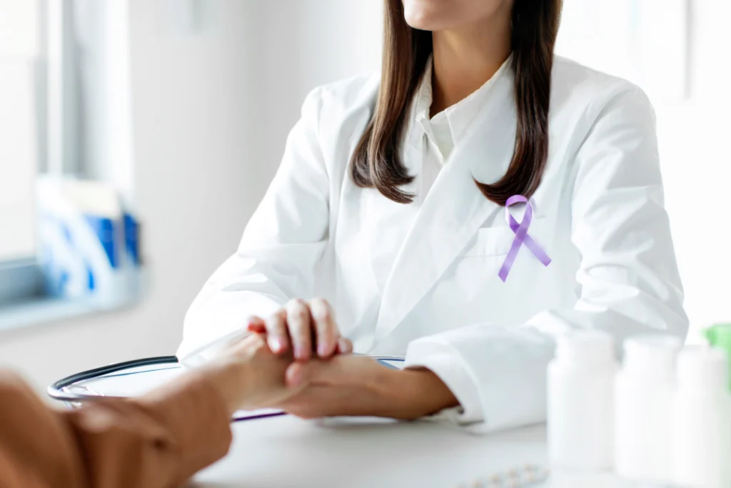 A doctor wearing a purple ribbon supports a patient during a consultation for National Cancer Prevention Month.