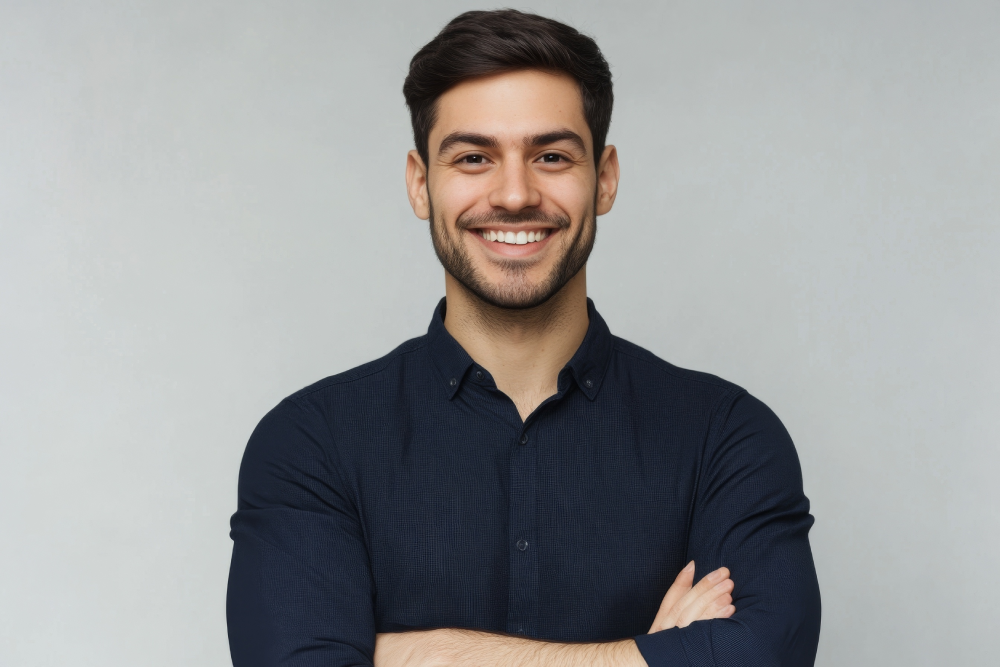 Smiling man standing confidently with arms crossed promoting men's health awareness.