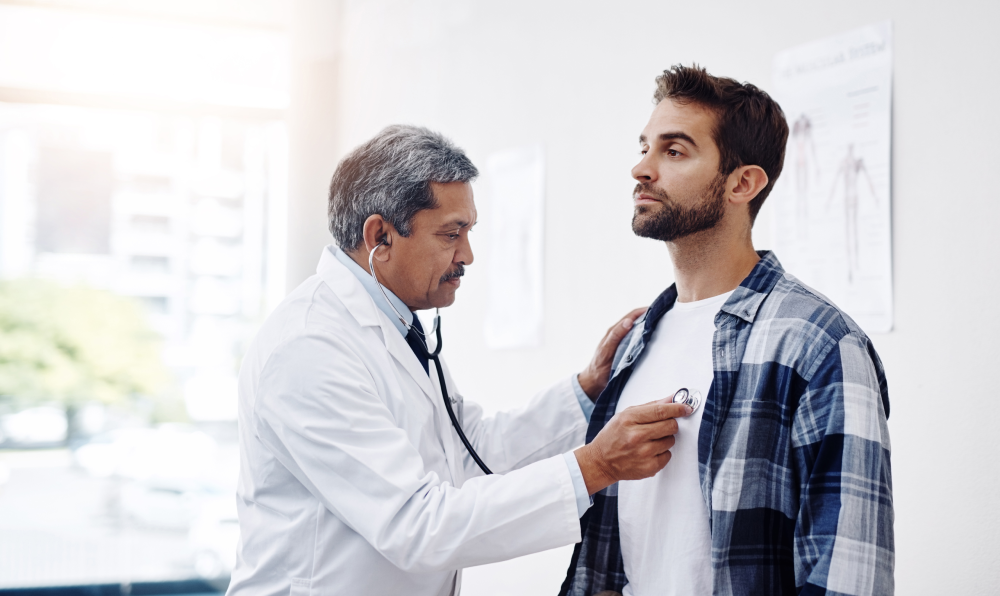 Doctor performing a physical checkup on a male patient for men’s health awareness.